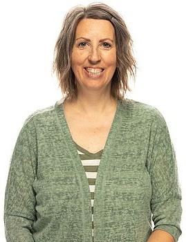 Headshot photo of Joan Wright standing in front of a white background.